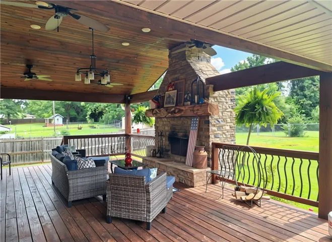 A spacious covered patio provides a delightful outdoor living space with a stately stone fireplace.