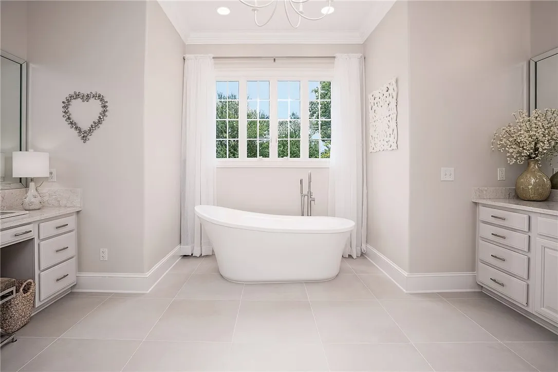 An inviting bathroom offers a deep soaking tub and dual vanities with ample storage.