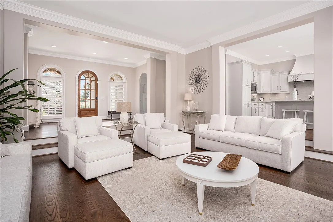 Rich hardwood flooring and crisp white trimwork enhance the generous proportions of this well-lit living area.