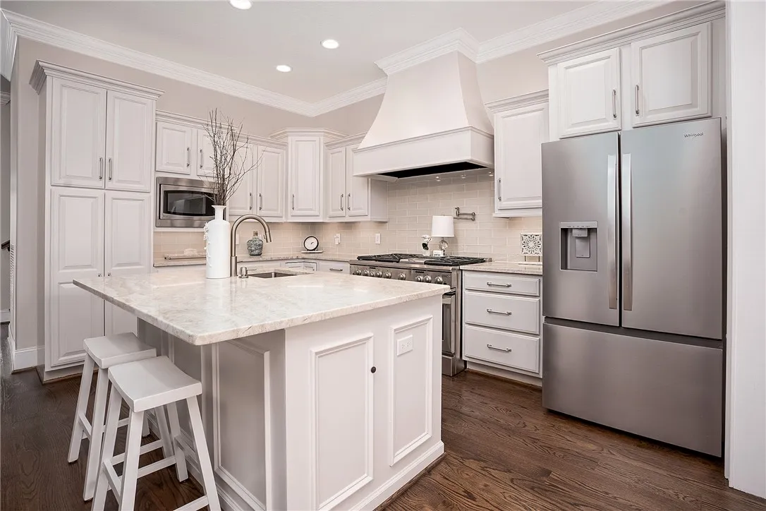 Culinary delights await in this bright kitchen with a spacious island and gleaming stainless steel appliances.