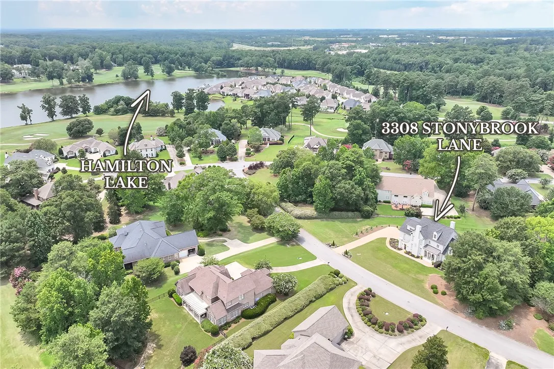 An aerial perspective reveals a serene community with ample green space and nearby lake views.