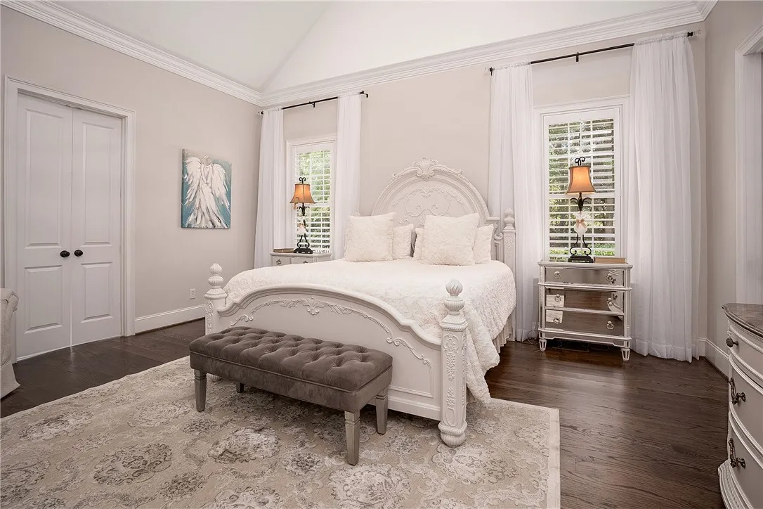 Luxurious hardwood floors complement a spacious sleeping area with graceful vaulted ceilings.