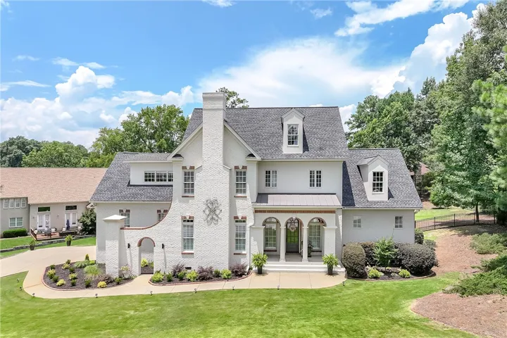 Grand brick facade with archways welcomes guests to this distinguished residence.