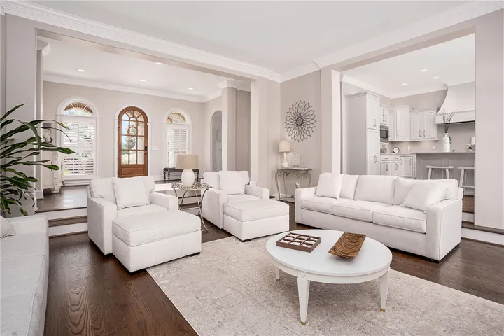 Rich hardwood flooring and crisp white trimwork enhance the generous proportions of this well-lit living area.