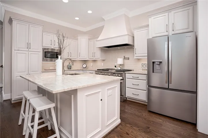 Culinary delights await in this bright kitchen with a spacious island and gleaming stainless steel appliances.