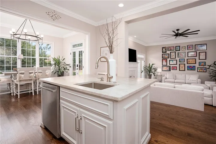 An open floorplan seamlessly connects the well-lit dining area with a modern kitchen island and a welcoming living space.