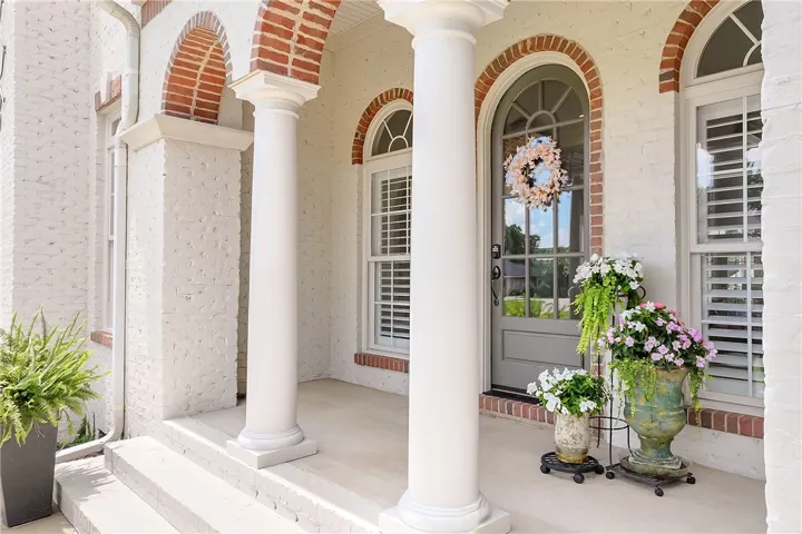 A graceful entry with arched brick detailing and stately columns welcomes guests to this inviting home.