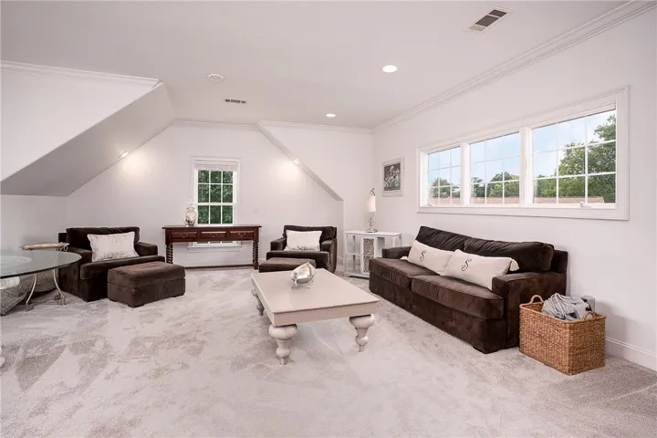 This airy room features sloped ceilings and ample natural light from multiple windows, perfect for relaxation.