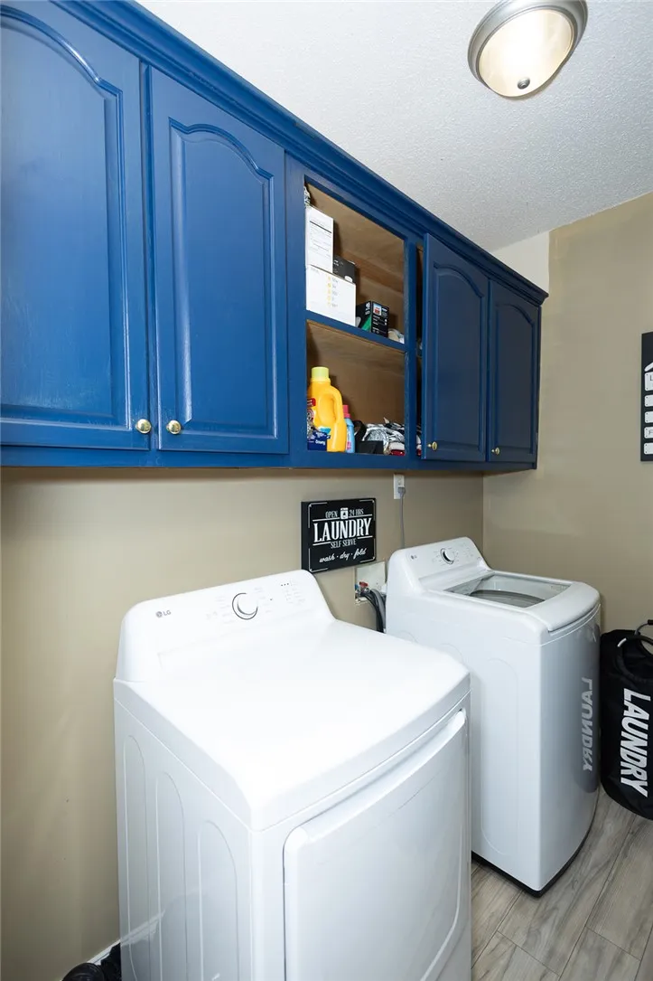 Functional laundry room offers vibrant blue cabinetry and modern appliances for efficient chores.