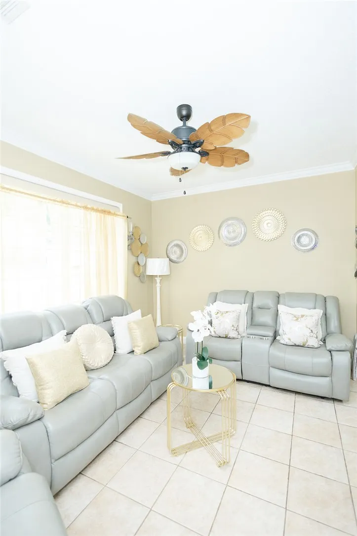 Relax in this living area featuring a ceiling fan and tiled flooring.