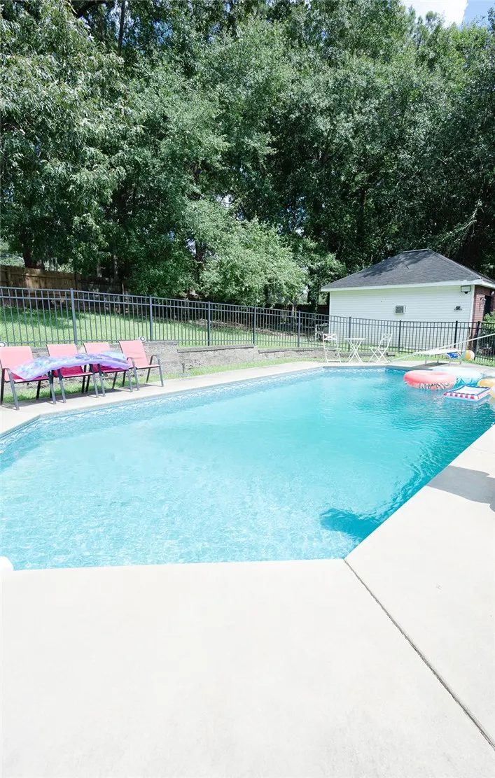 An inviting backyard oasis features a fenced-in pool area, perfect for summer enjoyment.