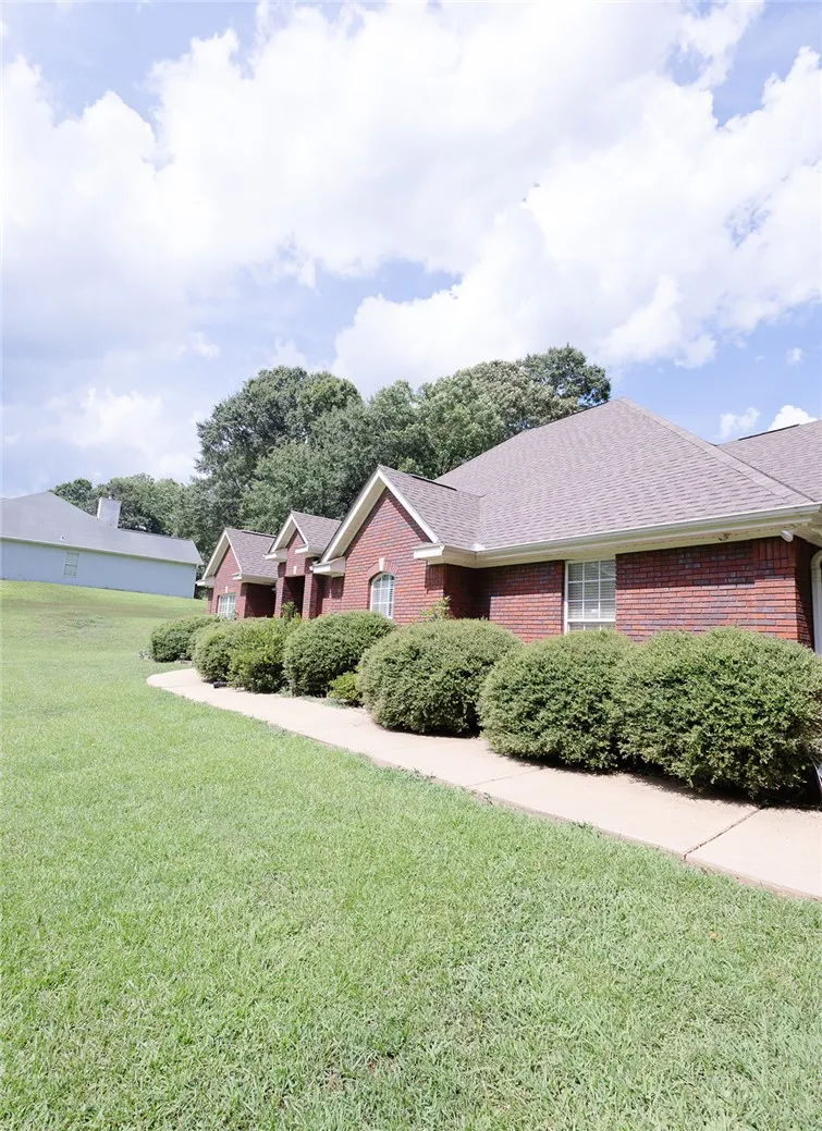 A classic brick exterior offers enduring charm, complemented by mature landscaping and a well-maintained pathway.