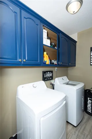 Functional laundry room offers vibrant blue cabinetry and modern appliances for efficient chores.