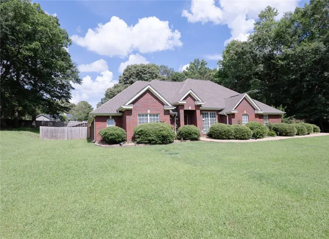A classic brick exterior with mature landscaping presents a welcoming presence.