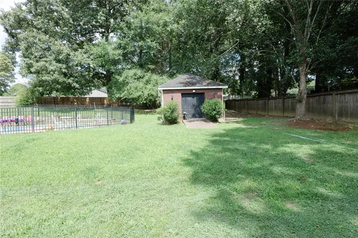 A spacious backyard features a brick outbuilding, fenced swimming pool, and mature trees.