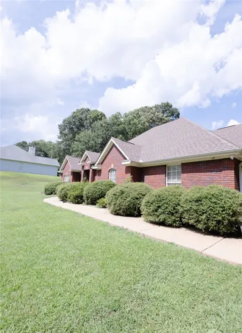 A classic brick exterior offers enduring charm, complemented by mature landscaping and a well-maintained pathway.
