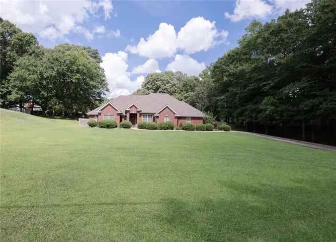A classic brick residence nestled on an expansive, well-maintained lawn.