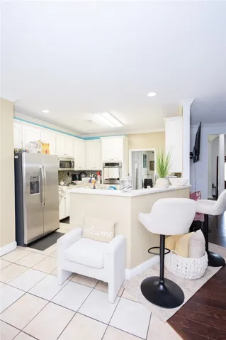 A well-lit kitchen with classic white cabinetry and a practical breakfast bar.