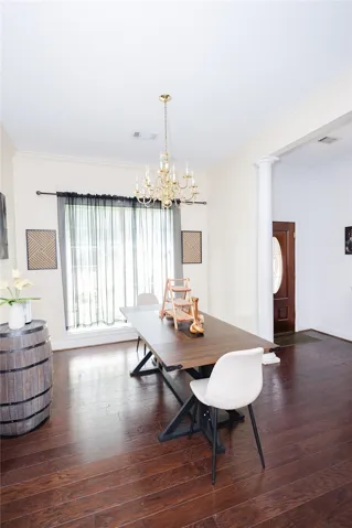 Elegant crown molding and rich hardwood flooring define this inviting dining area.