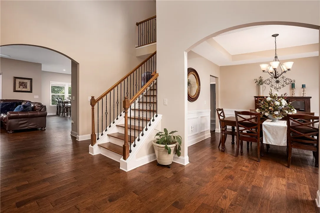 Rich hardwood floors welcome you into a spacious entrance foyer with an elegant staircase and an adjoining dining room.