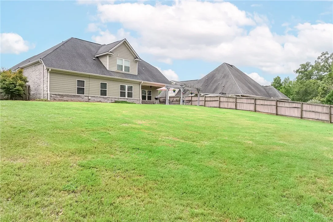 A spacious, verdant yard provides ample outdoor living space behind a well-maintained residence.