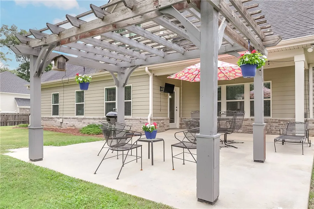A private backyard oasis features a spacious concrete patio, ideal for outdoor entertaining and relaxation.