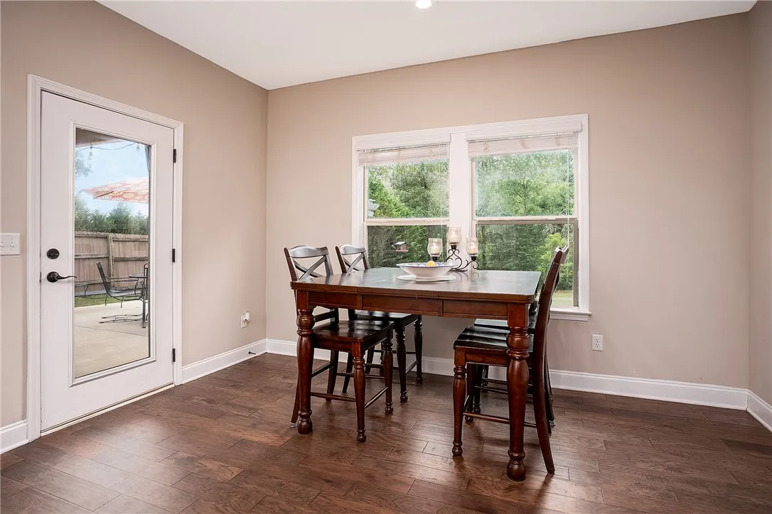 Hardwood floors and generous natural light define this cozy dining space, offering direct access to the outdoor patio.
