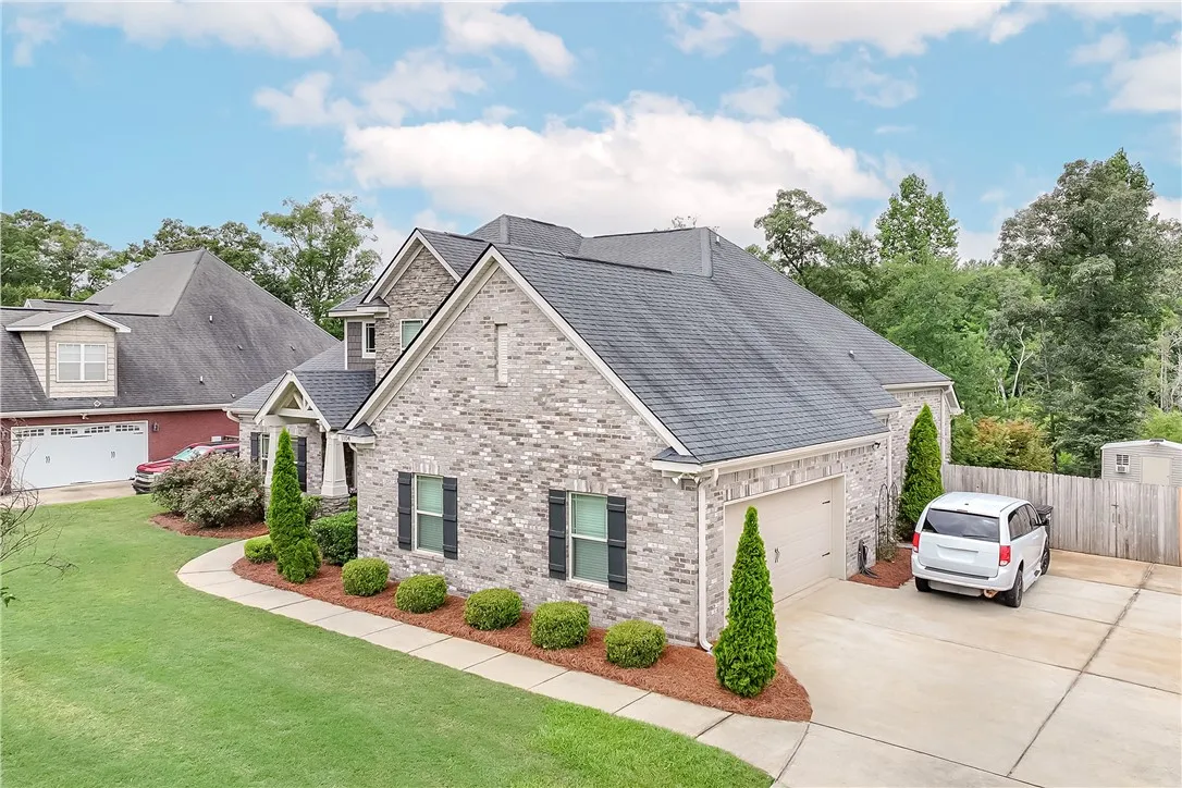 A classic brick exterior with dark shutters offers inviting curb appeal and manicured landscaping.