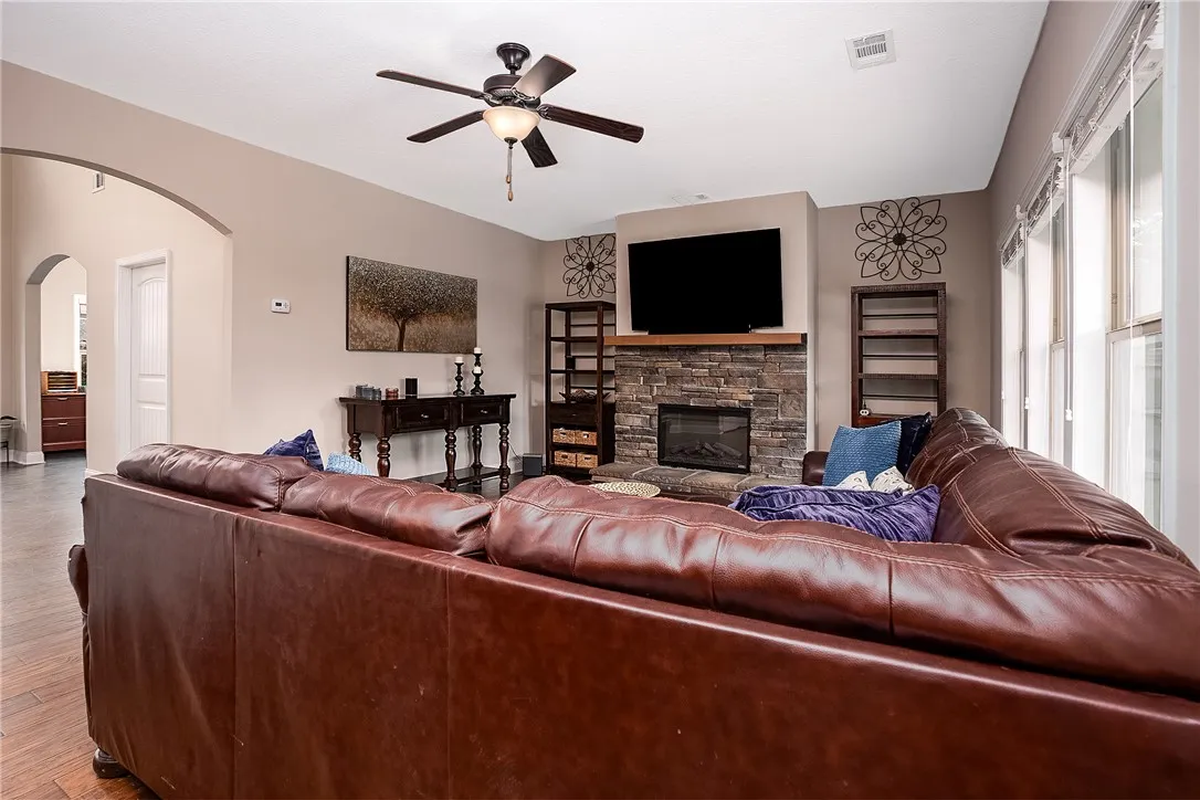 An inviting family room showcasing a cozy fireplace and rich hardwood flooring, perfect for gatherings.