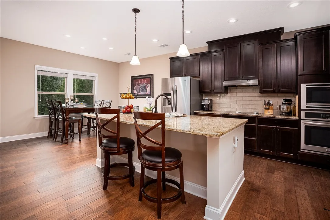 A well-appointed kitchen showcasing rich cabinetry and natural light, perfect for entertaining.