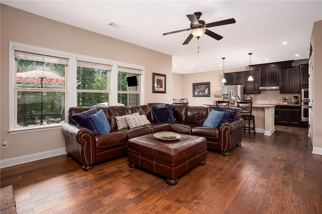 An open-concept living space boasts rich hardwood flooring and a functional kitchen, perfect for entertaining.