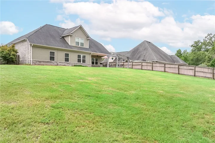 A spacious, verdant yard provides ample outdoor living space behind a well-maintained residence.