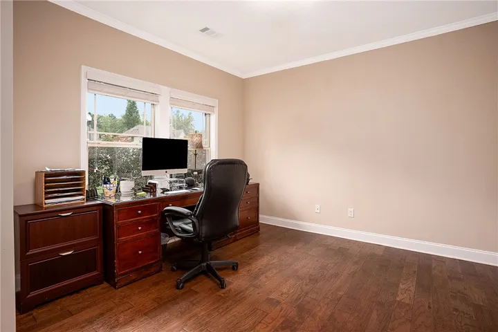 Hardwood floors and generous windows frame this ideal home office space.