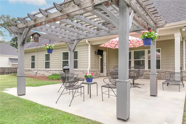 A private backyard oasis features a spacious concrete patio, ideal for outdoor entertaining and relaxation.