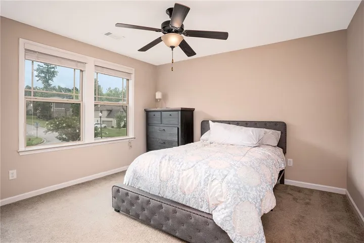 A quiet retreat with a comfortable ambiance, this bedroom includes soft carpeting and abundant natural light.
