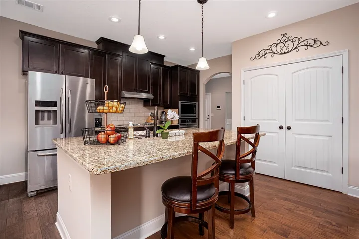 A well-appointed kitchen features dark wood cabinetry, granite countertops, and modern appliances.