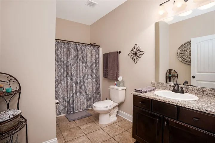 Granite counters complement the dark wood vanity in this well-appointed bathroom.