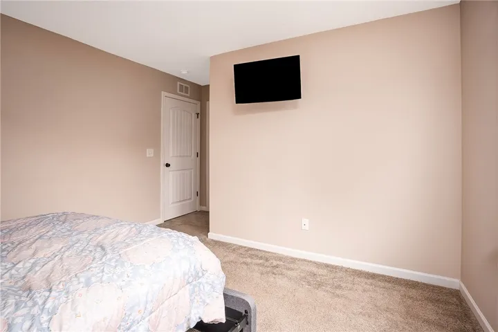 Well-lit sleeping quarters with plush carpet and a clean, neutral palette.