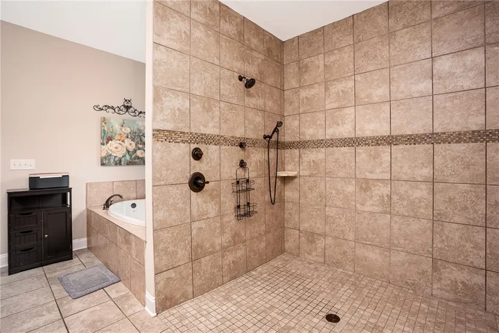 Indulge in a luxurious primary bathroom featuring a spacious walk-in shower and a corner soaking tub.