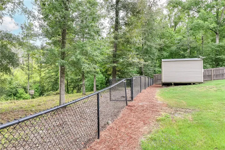 A fully fenced backyard with a useful storage shed for all outdoor needs.