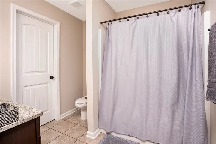 Granite counters and tiled floors create a fresh, clean aesthetic in this well-appointed bathroom.