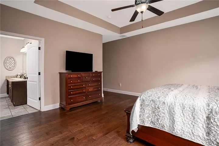 Elegant tray ceilings and warm hardwood floors define this inviting sleeping sanctuary.