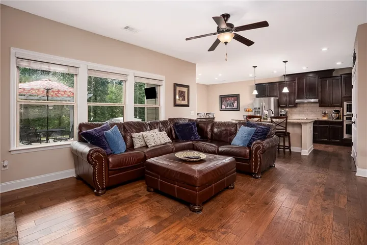An open-concept living space boasts rich hardwood flooring and a functional kitchen, perfect for entertaining.