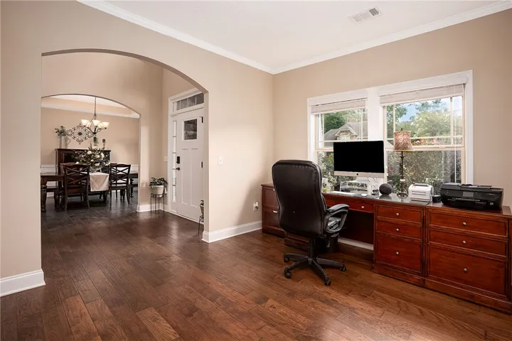 Rich hardwood floors flow through this flexible space, perfect for a home office or formal dining.