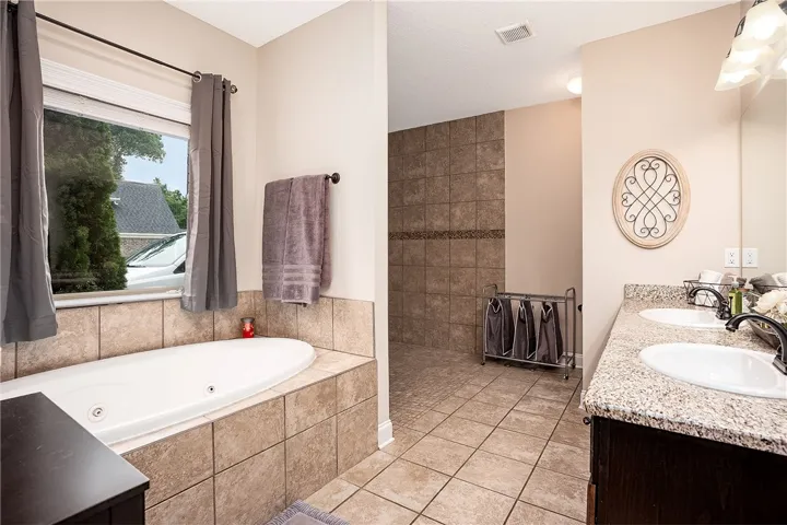 Relax in the deep soaking tub or prepare for your day at the double vanity in this primary bath.