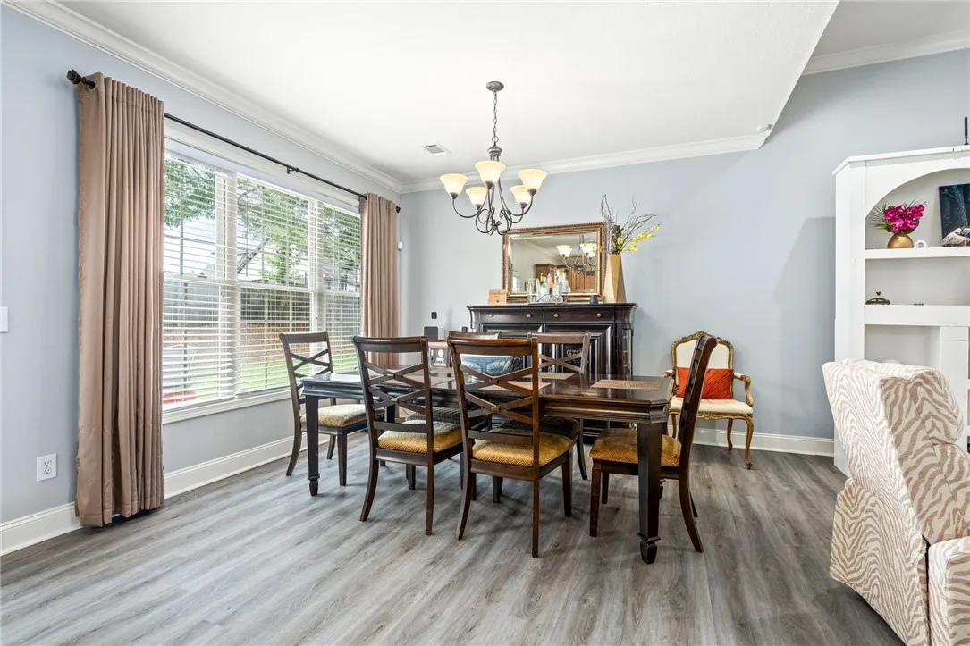Hardwood-style flooring and crown molding define this welcoming dining space.