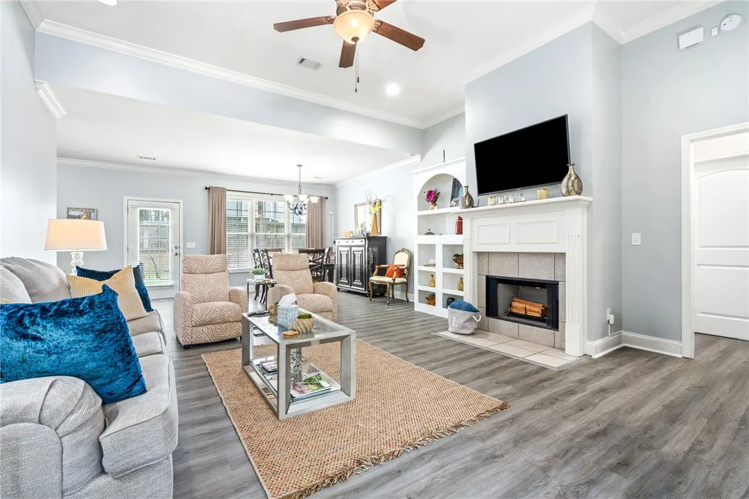 Warm, inviting living space features an open layout with a fireplace and built-in shelving.