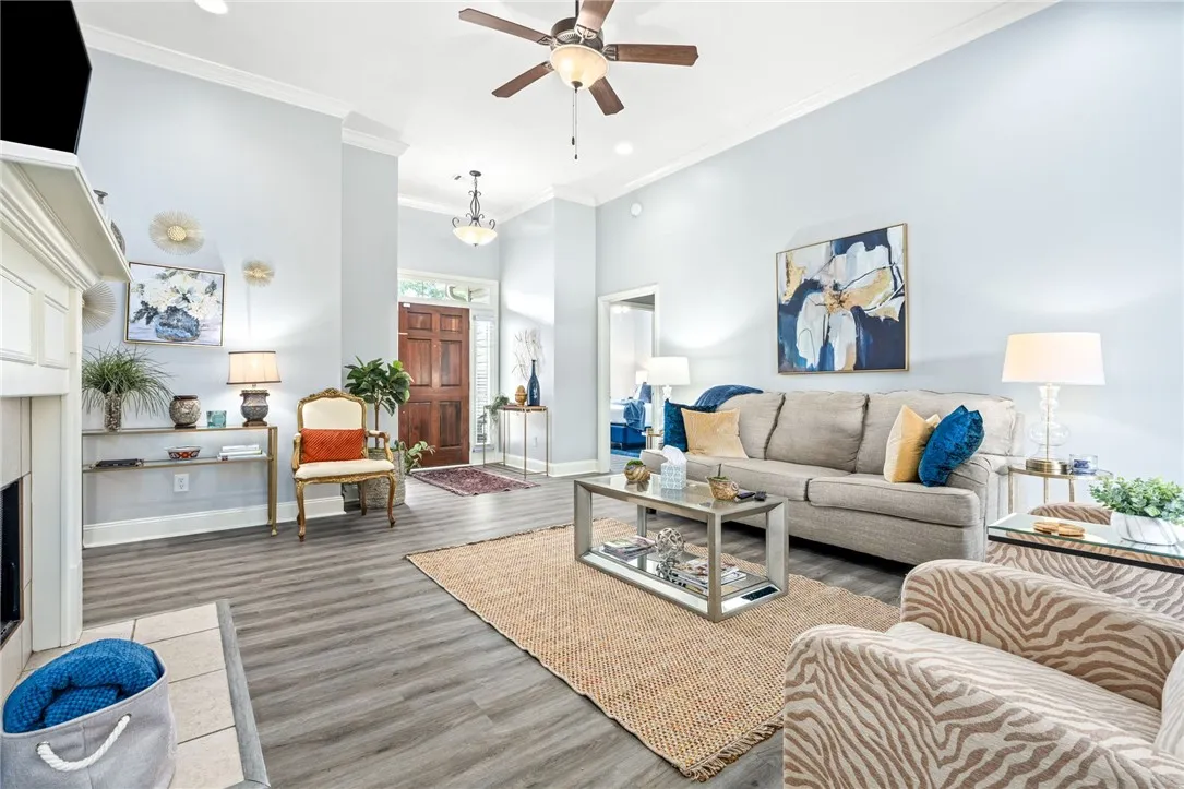 Enter into a welcoming living space boasting high ceilings, crown molding, and durable plank flooring.