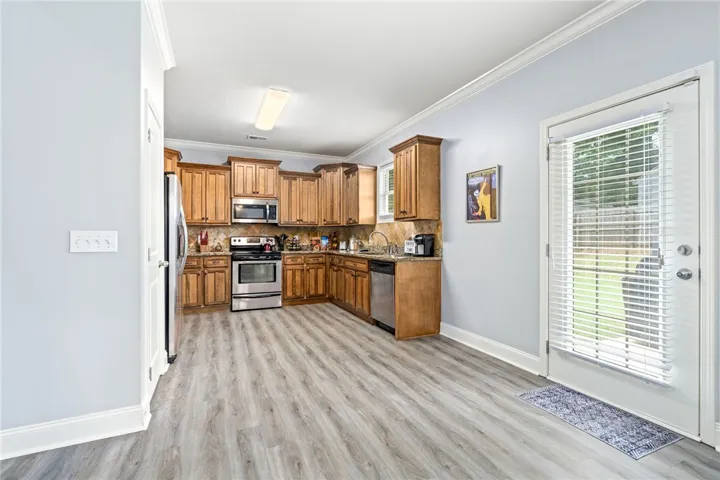 A well-appointed kitchen features ample cabinetry, durable flooring, and convenient outdoor access.