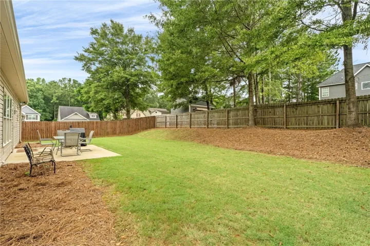 A spacious, manicured lawn with a concrete patio perfect for outdoor entertaining.